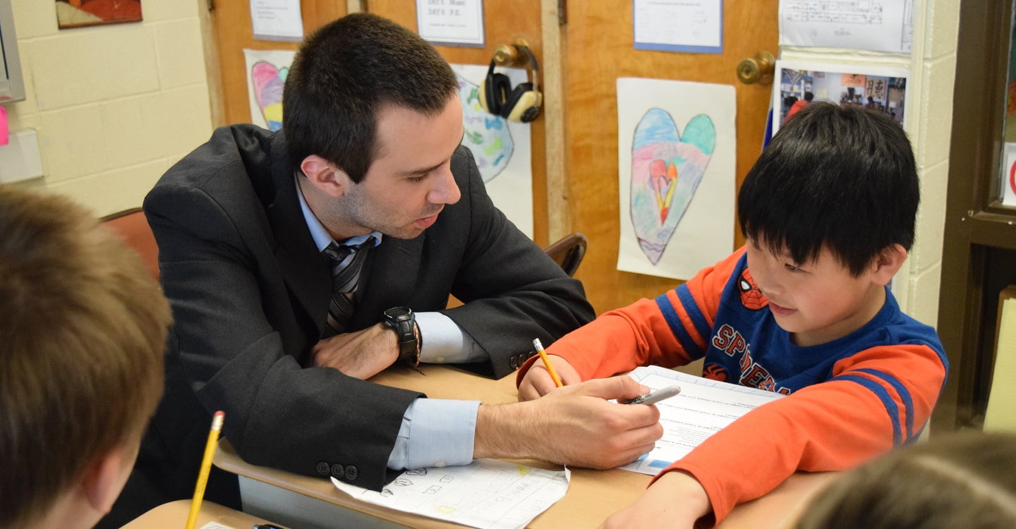 Hartwick education student working with elementary school student in classroom