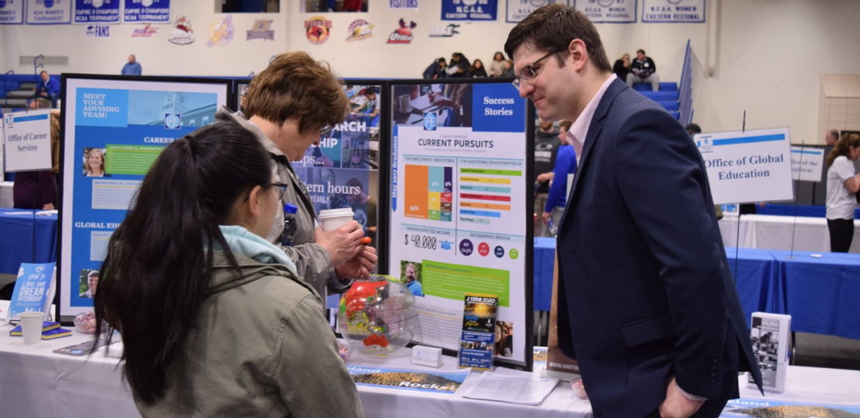 Global Education Advisor talking with student and family member during Accepted Student Day