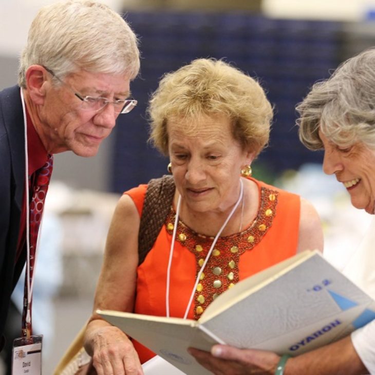 Alumni looking at yearbooks during True Blue Weekend
