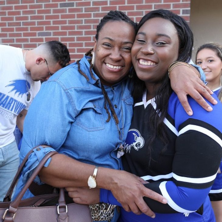Smiling mom and cheerleader during True Blue Weekend