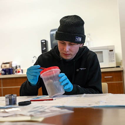 Hartwick College student in forensic science course with testing sample