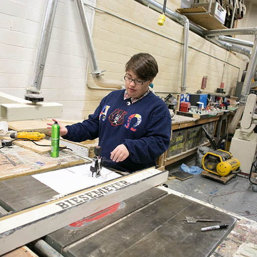 Hartwick theatre student working on stage set