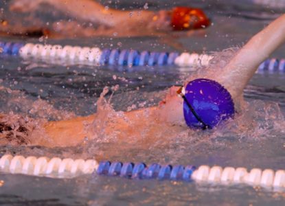 Hartwick student swimming backstroke