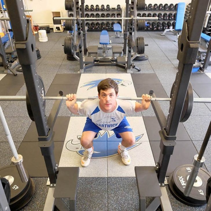Hartwick student lifting weights in the Elting Fitness Center