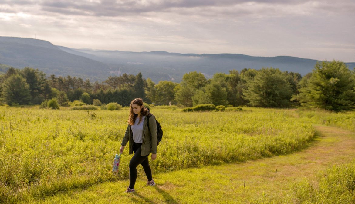 Hartwick student walking on Stawberry Field