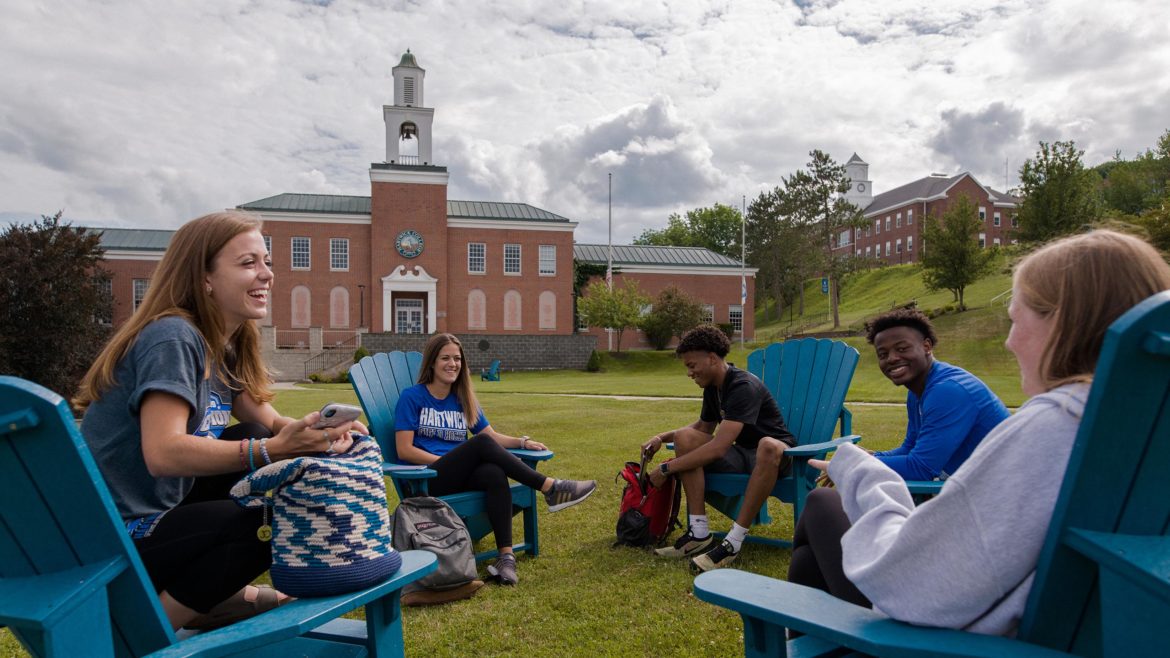 Hartwick students sitting on Frisbee Field