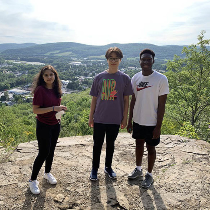 Hartwick students at top of Oyaron Hill on campus with view of valley