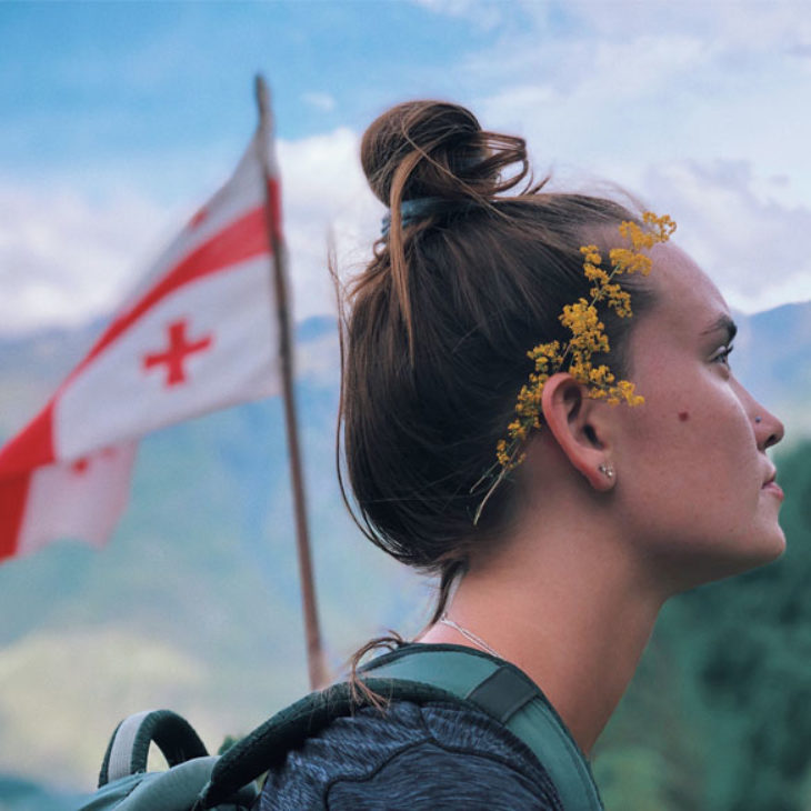 Hartwick student posing in front of the Georgian flag, Georgia