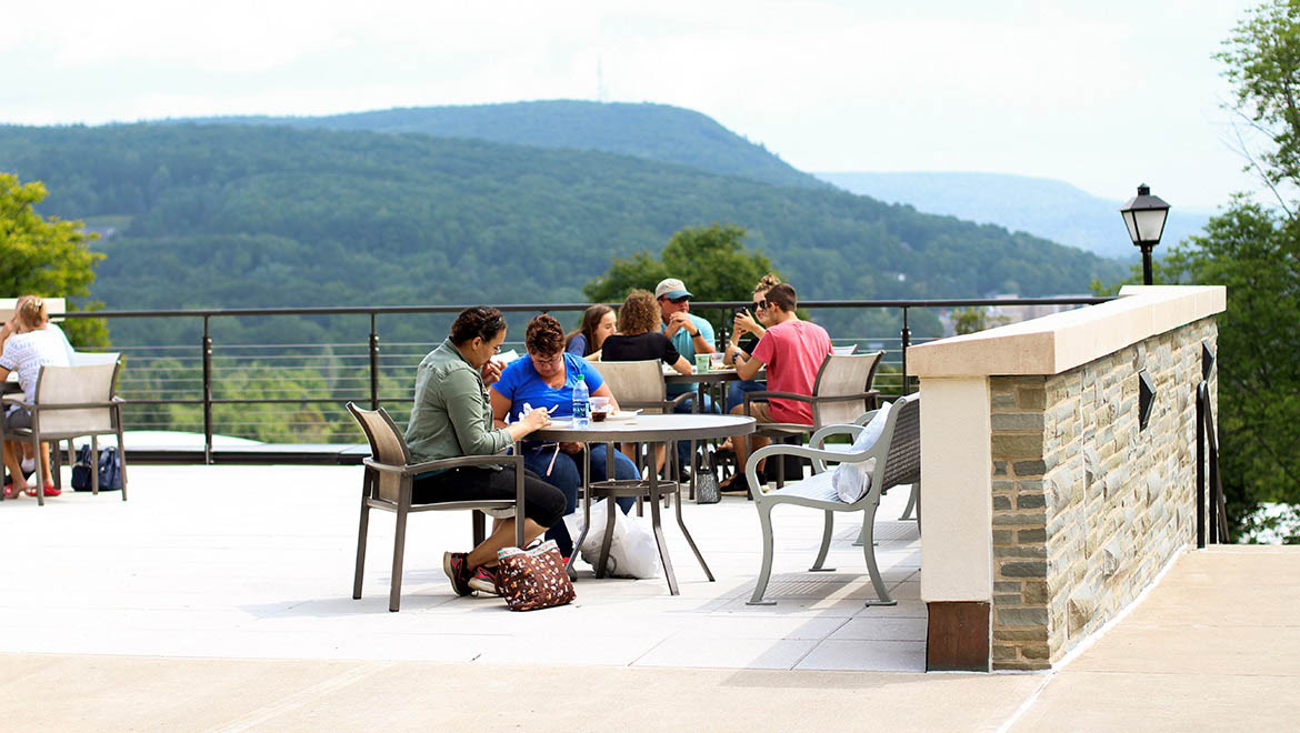 Students sitting at tables on Stack Patio