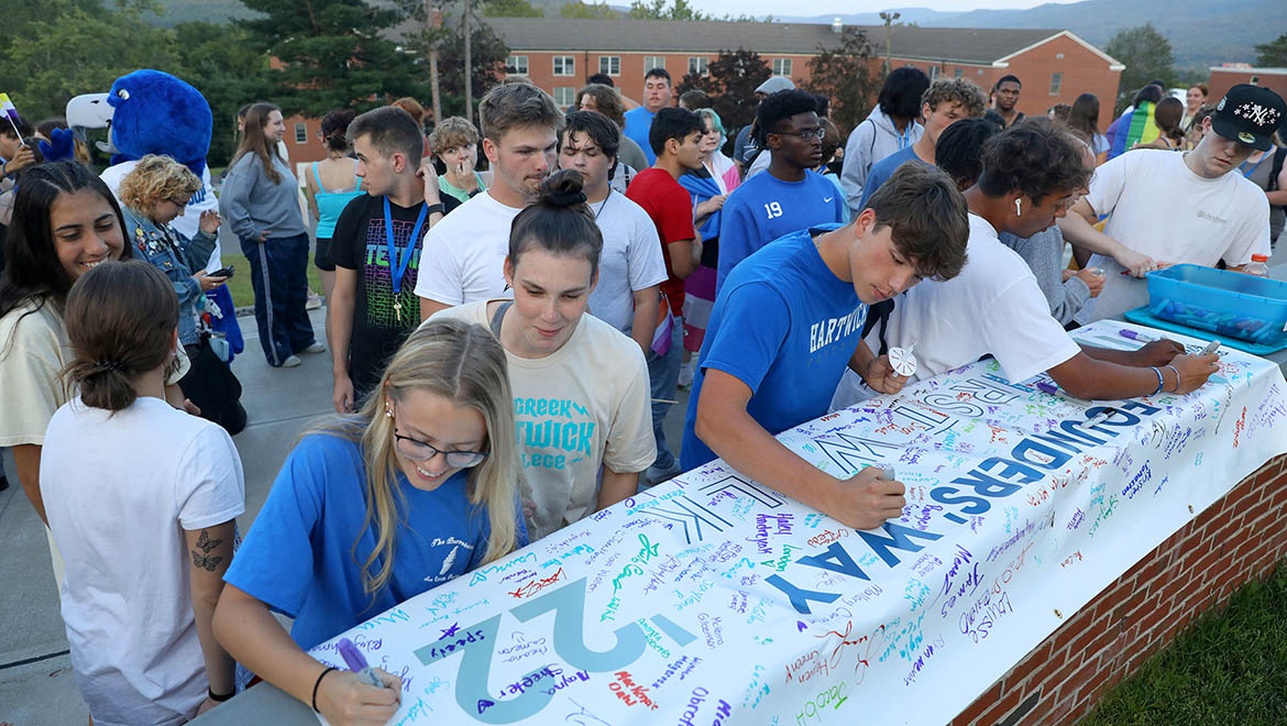 Hartwick students signing First Walk banner for the end of Wick Week '22