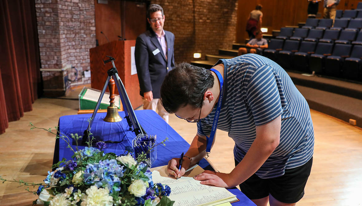 Hartwick student signing the College's Matriculation Book with President Reisberg