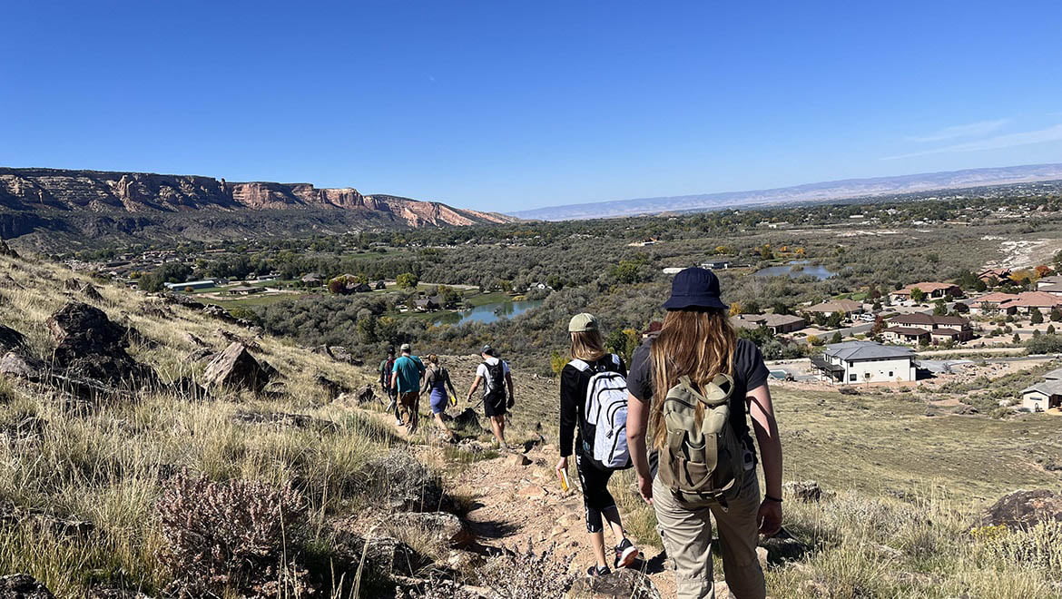 The students hike a short trail to the historic Riggs Hill dinosaur quarry in Grand Junction, CO