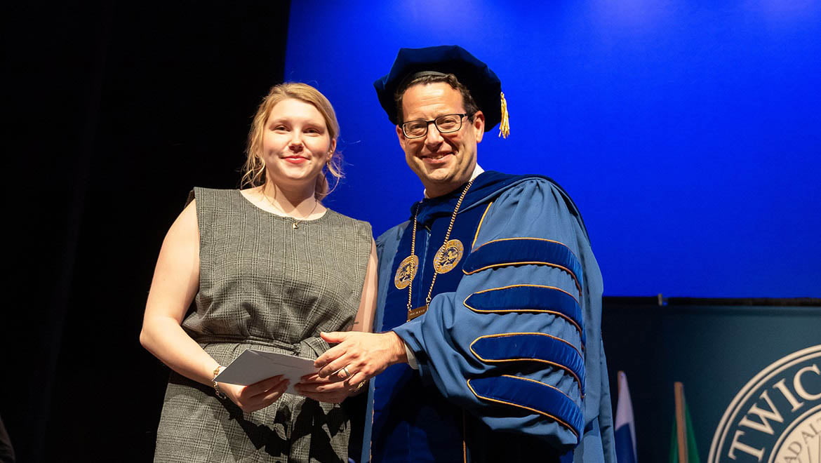 President Reisberg congratulating student during Honors Convocation, May 3, 2023