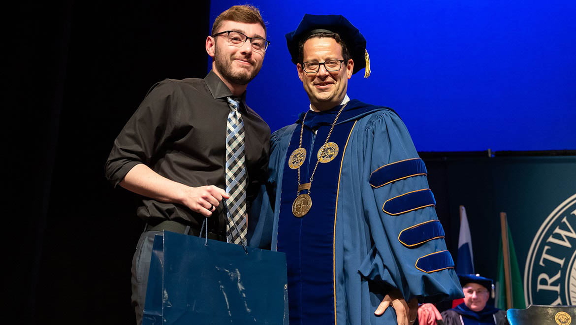 President Reisberg congratulating student during Honors Convocation, May 3, 2023