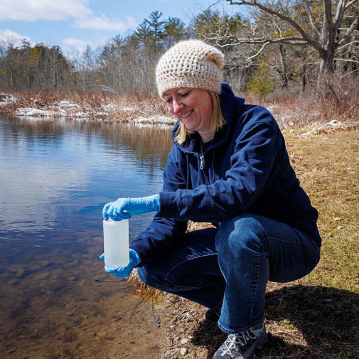 Dr. Z with water sample at shore of Pine Lake