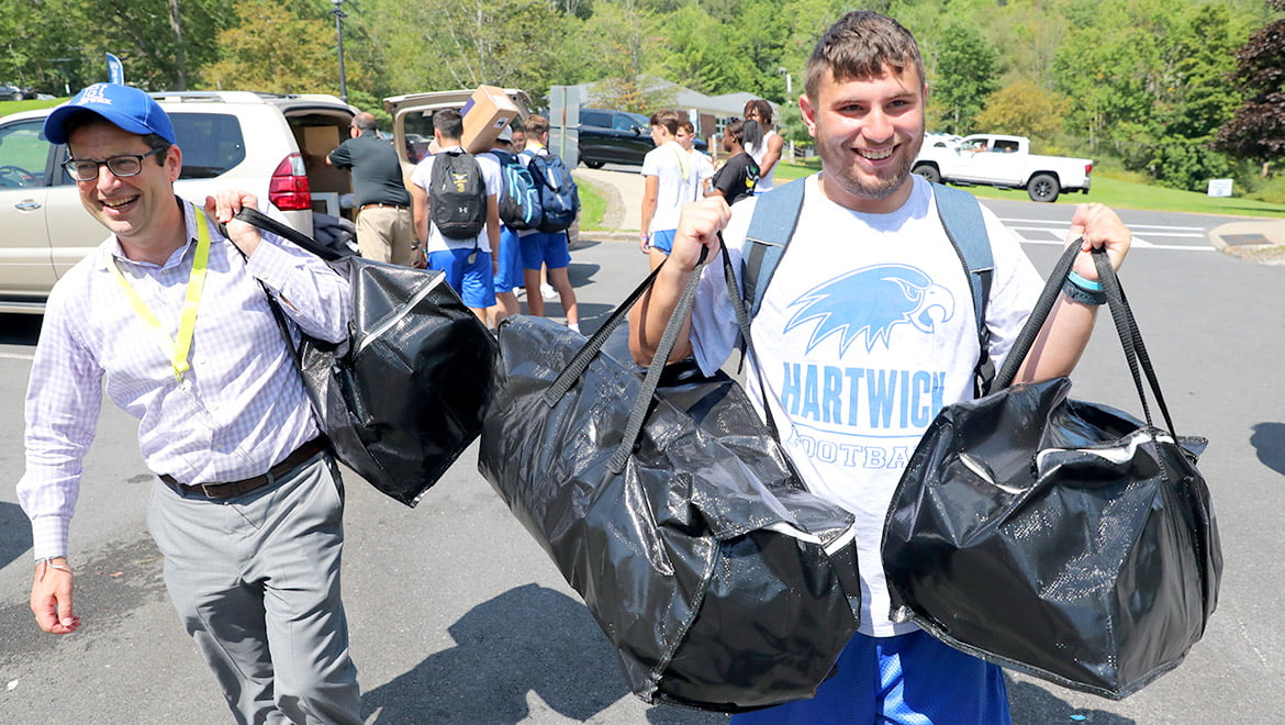 Hartwick College Darren Reisberg works with the football team to help new students move in during Wick Week