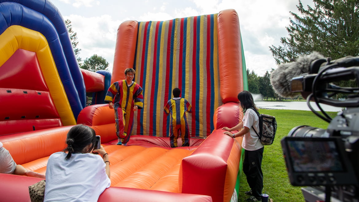 New Hartwick College students having fun on velcro wall at carnival during Wick Week