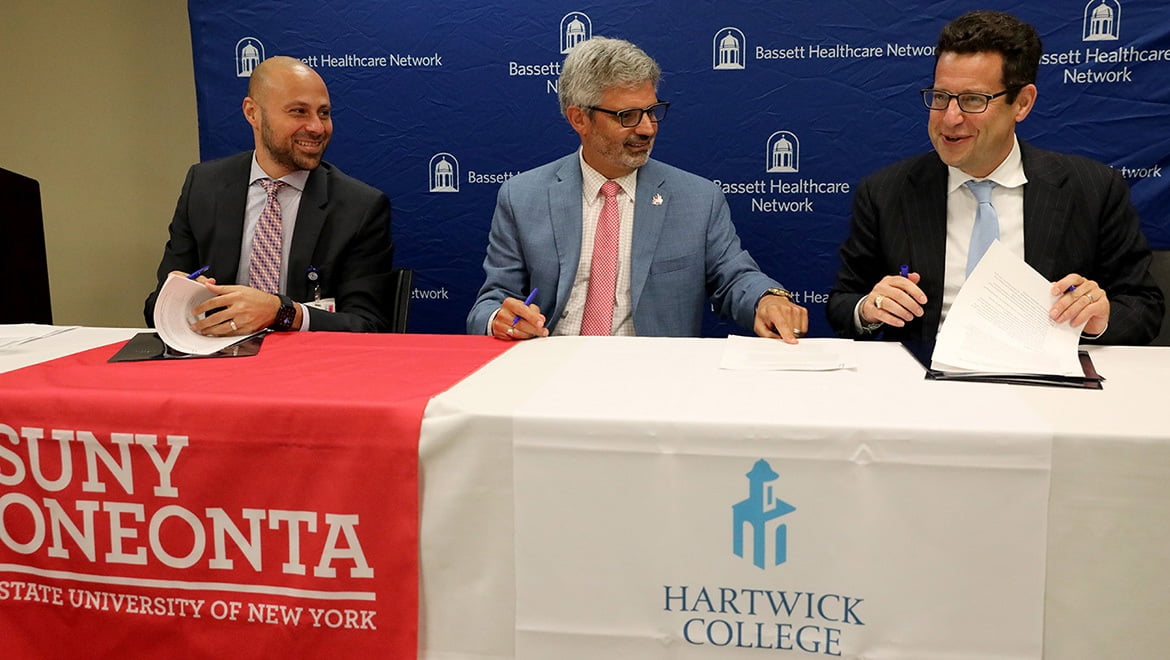 Dr. Tommy Ibrahim, President and CEO of Bassett Healthcare Network, SUNY Oneonta President Alberto Cardelle, Hartwick College President Darren Reisberg during the signing of the new Bassett CARES partnership agreement