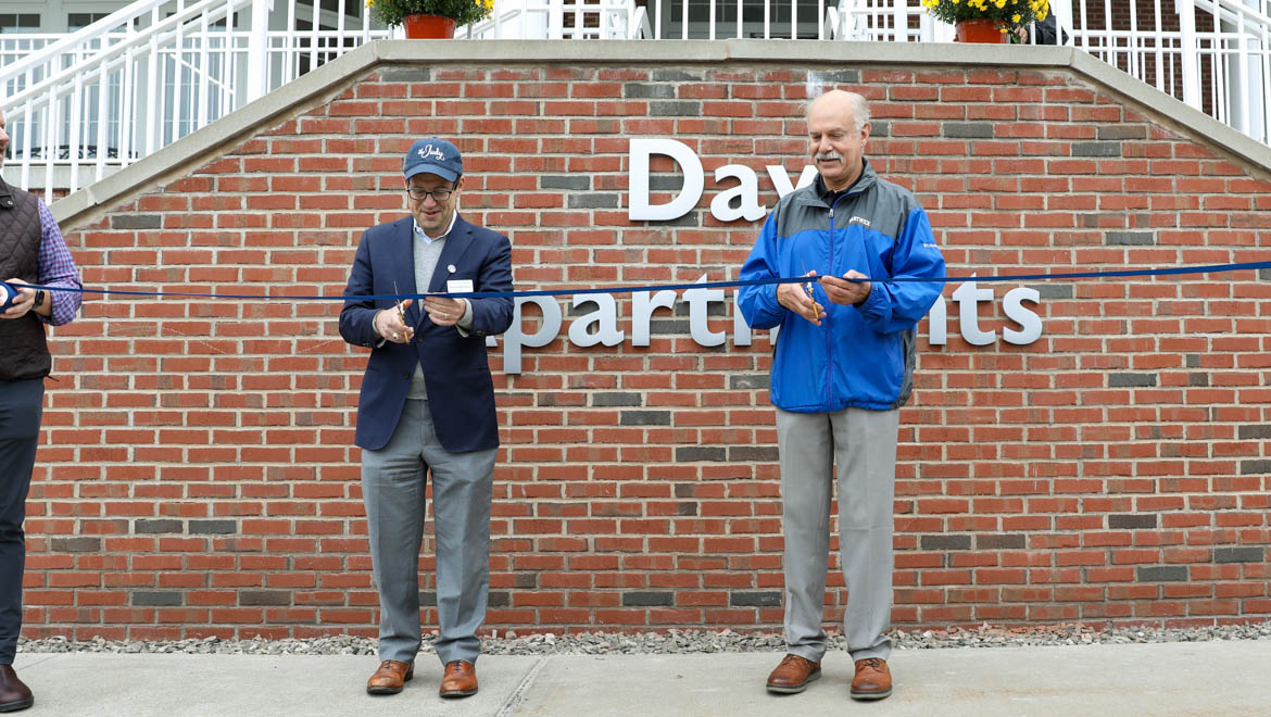 President Darren Reisberg and Larry Miller cut ribbon at Day Apartments