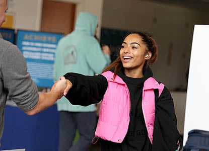 Hartwick College student shaking hands with professional during Industry Days event