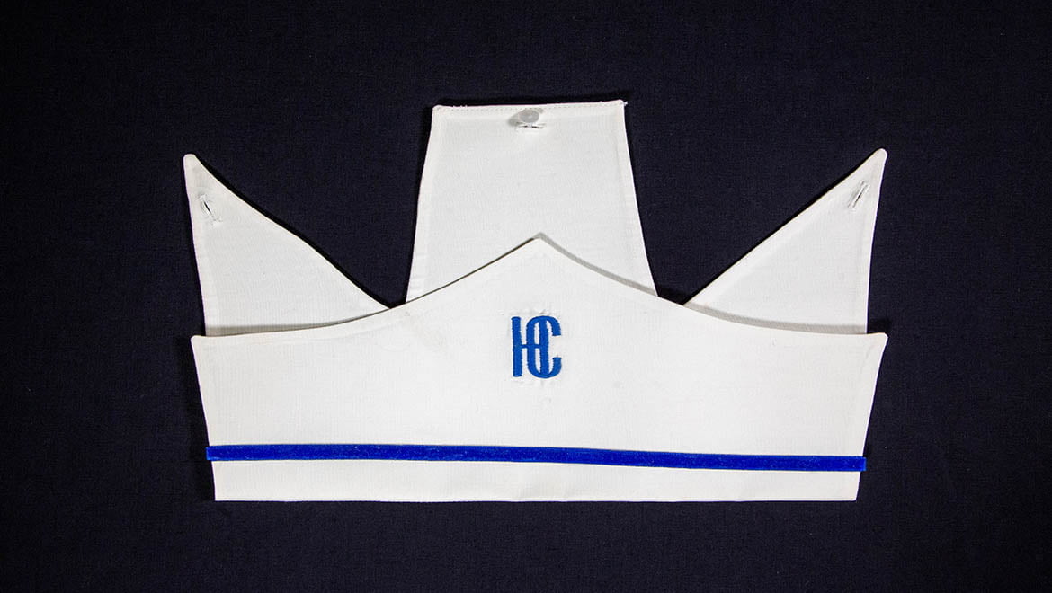 Hartwick College nursing plain white cap on which HC was embroidered in Hartwick blue