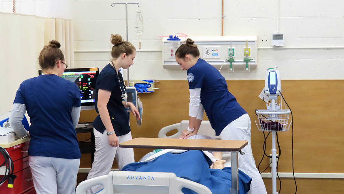 Hartwick College nursing students in Sim Lab running cardiac simulation on mannnequin