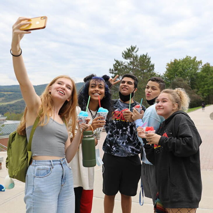 Hartwick College students taking selfie while enjoying snowcones on Founders' Way