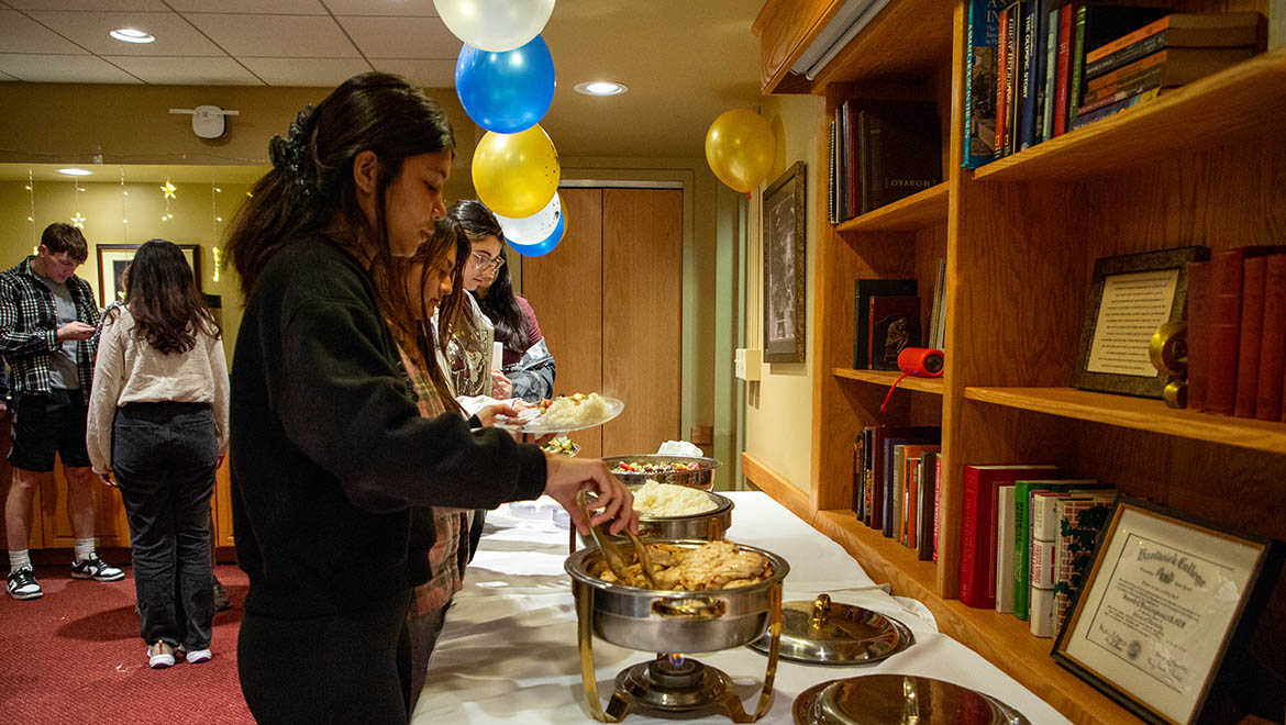 Hartwick students, faculty and staff attend the event Essence of Ramadan, students at buffet line.