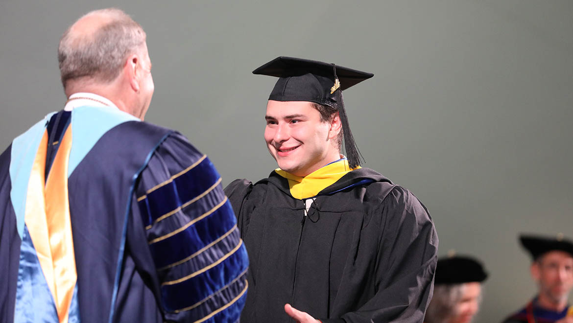 Hartwick College graduate being congratulated by Interim President Mullen