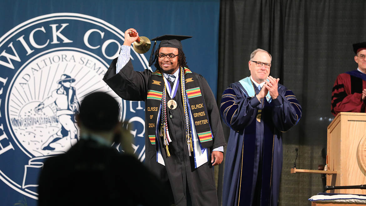 Hartwick College Student Government Association President Noah Hurt '24 ringing the Hartwick ceremonial bell to begin Commencement ceremony