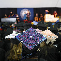 View of Hartwick College graduates decorated caps during commencement ceremony