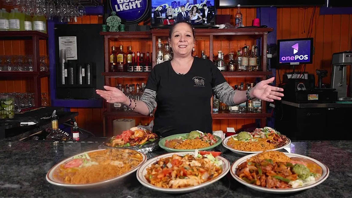 A waitress at Nuevo Acapulco, in the Cleveland suburb of Fairview Park, shows off some of her restaurant’s offerings. Its owners received a low-interest federal loan, with the help of Grow America, to acquire the property they had leased since 2018. Photo courtesy of Grow America