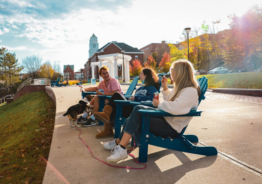 Hartwick College students sitting on Founders' Way