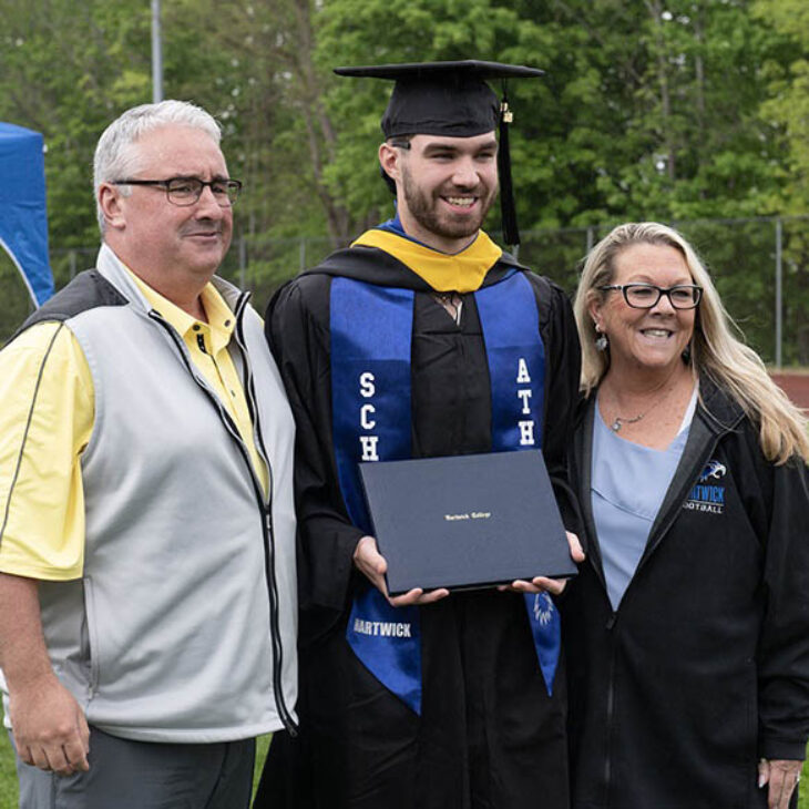 Hartwick College graduate with parents after Commencement