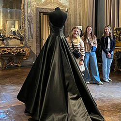 Hartwick College fashion merchandising students in Italy with fashion house dress on display