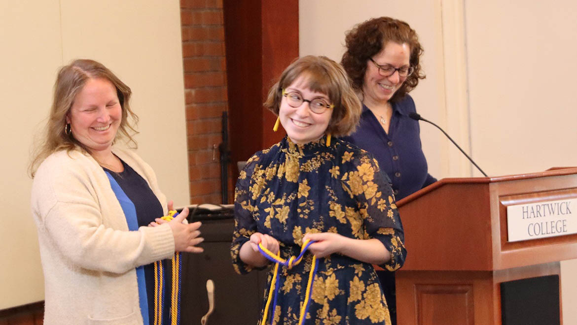 Hartwick College student receiving honor cords during Delta Alpha Pi Induction April 2025