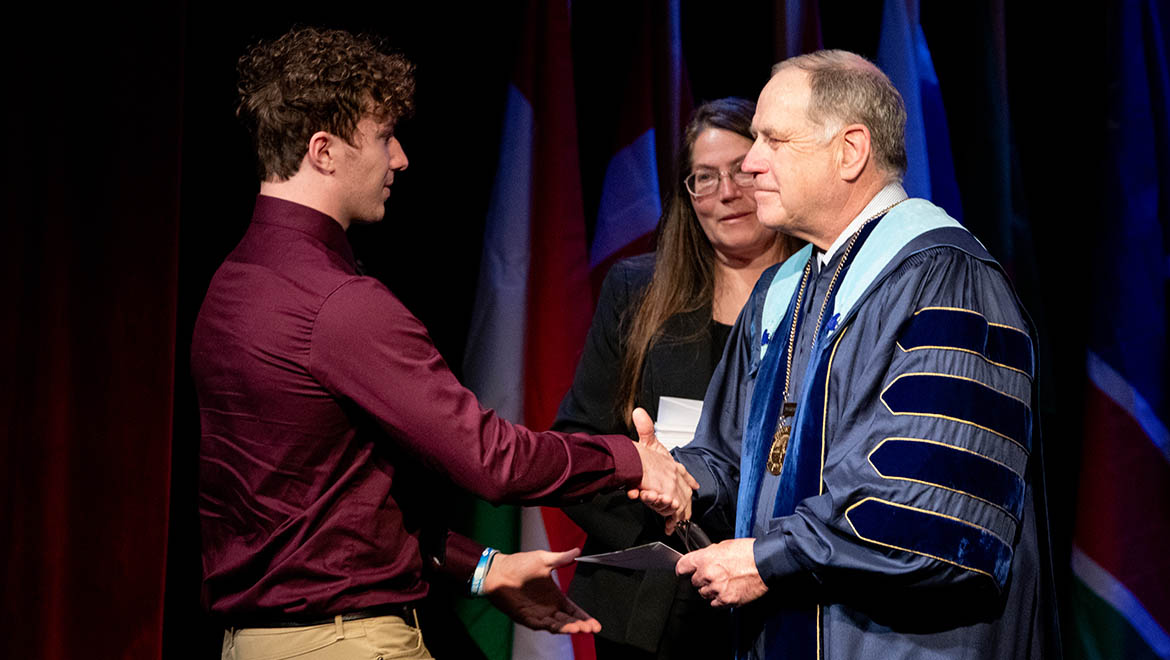 Hartwick College student shaking hands with President Mullen