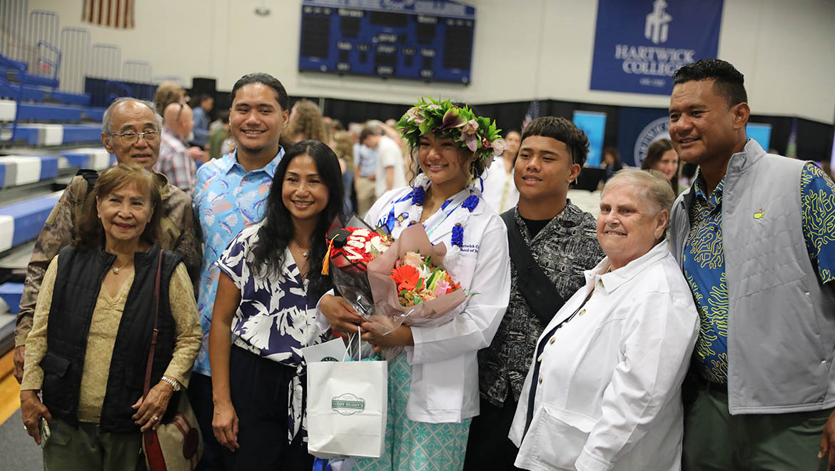 Hartwick College nursing graduate with family after nurses pinning ceremony