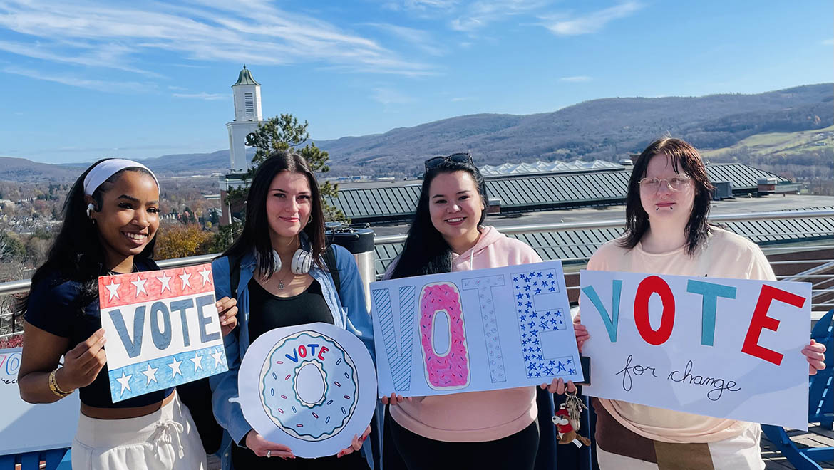 Hartwick College students with VOTE signs on campus for Donuts for Democracy Drive