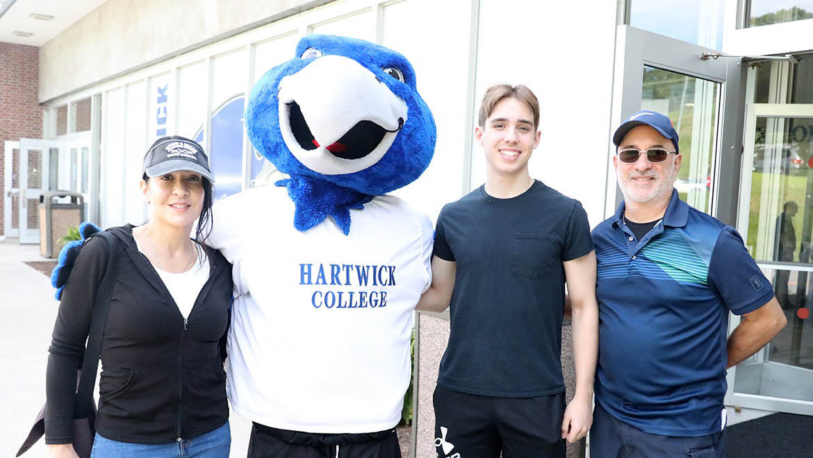 New Hartwick student with family posing for photos with Swoop