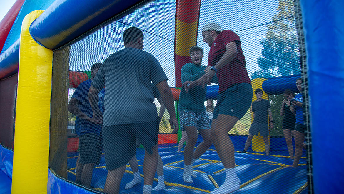 Hartwick College students bouncing in Bounce House during Wick Weekend Carnival on Frisbee Field