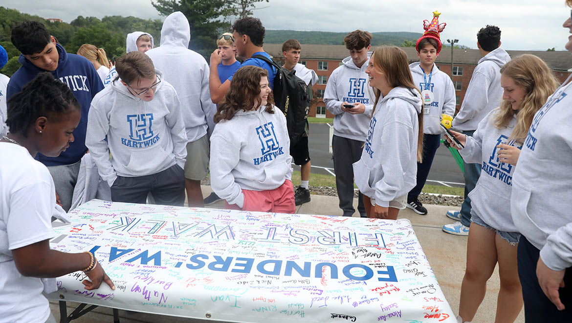 Hartwick College students gather to sign the First Walk banner