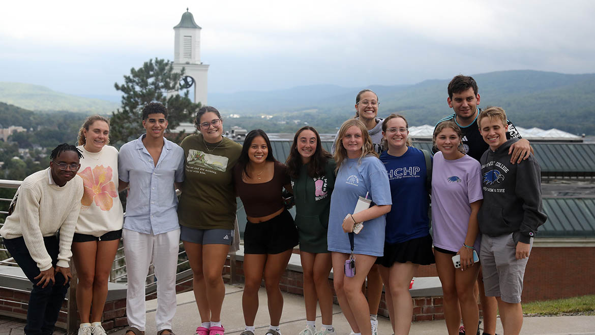 New Hartwick College students on Founders' Way with valley view and Yager Bell Tower in the background