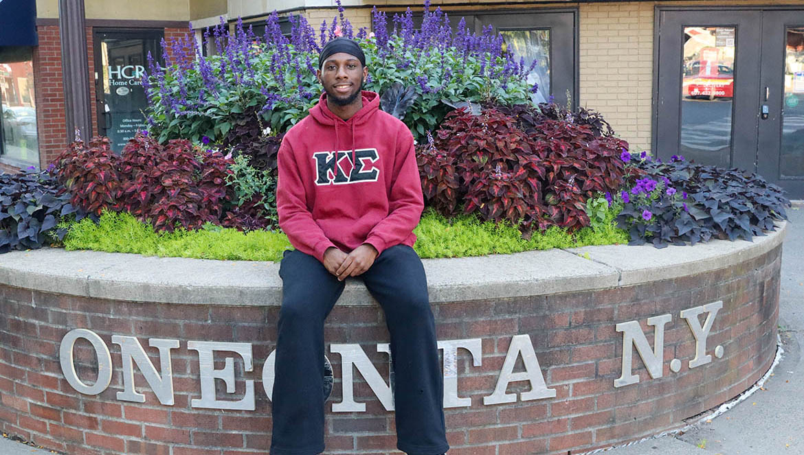 Hartwick College student Khadifi Madison '27 sitting on Main Street, Oneonta, NY