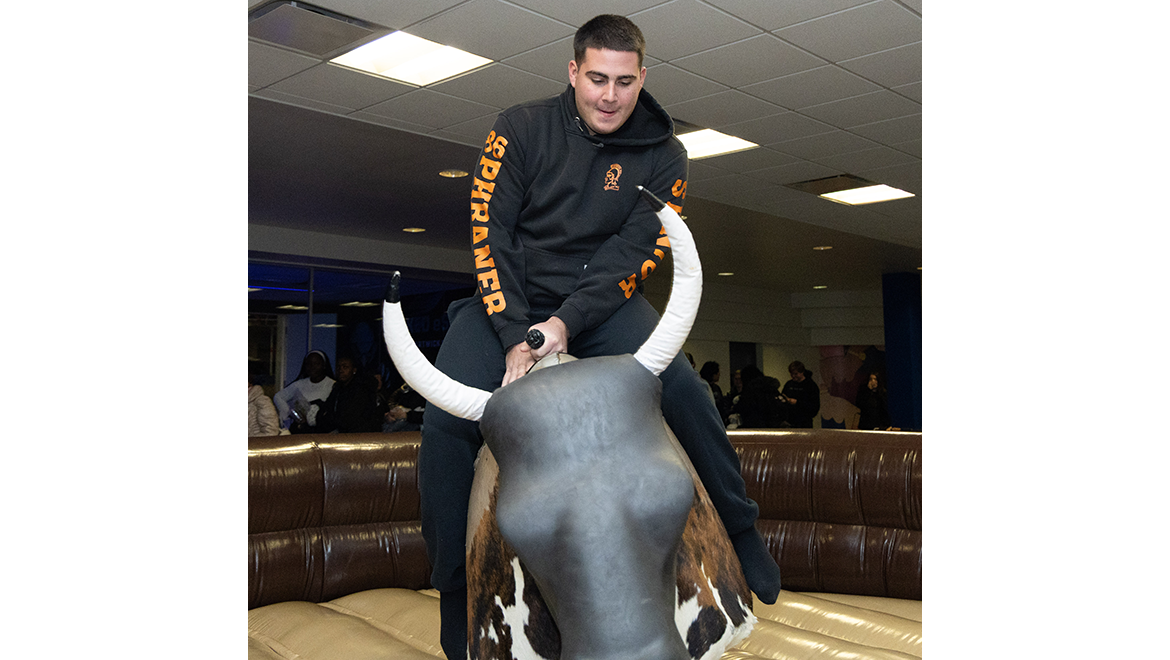 Hartwick College students at Wick Express Event riding bucking bull in Stack Lounge
