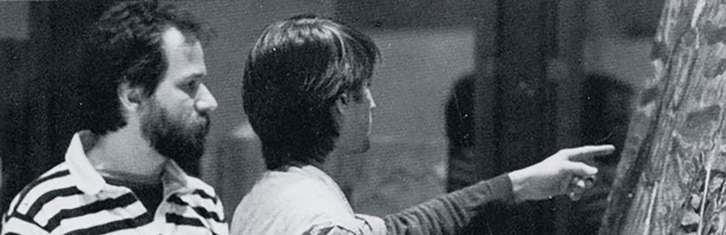 Professor Phil Young with student talking about painting