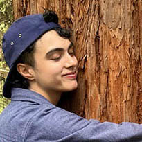 Sonder Prize winner Meer Singh hugging redwood