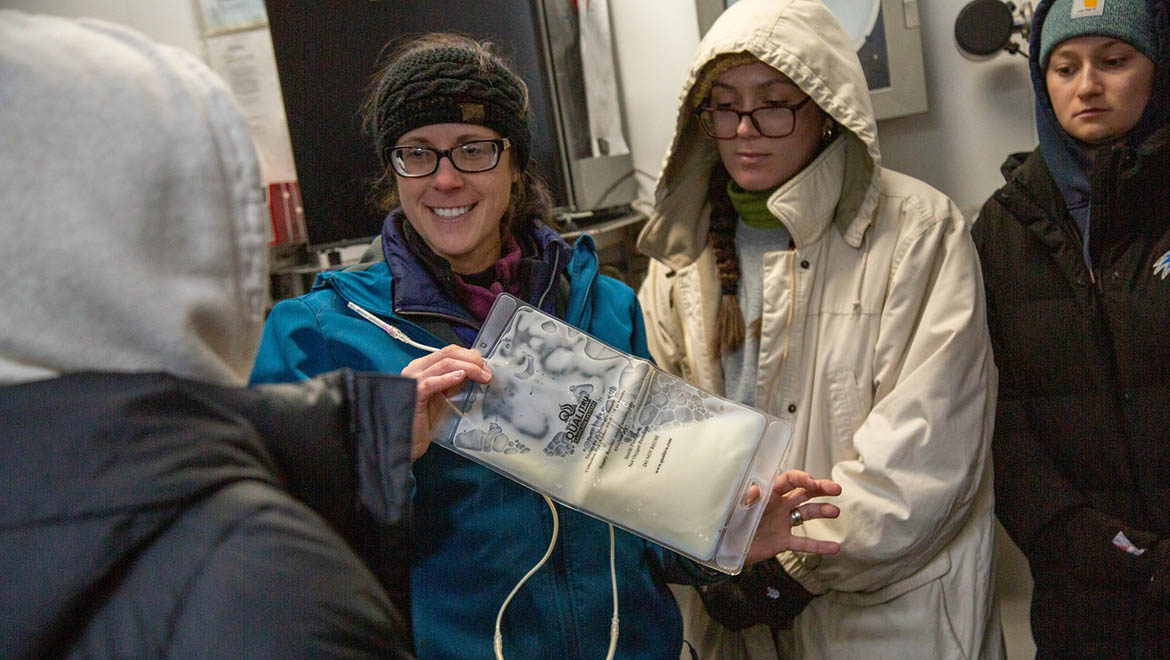 Hartwick College nursing students in dairy barn holding fresh milk bag