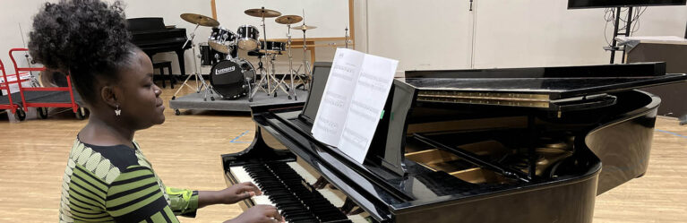 Hartwick music student playing piano in music practice room
