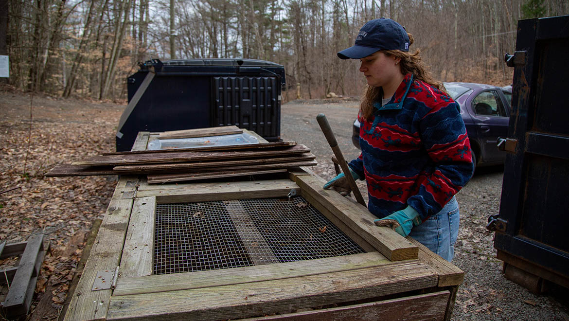 Abi DeMan ’26 at compost bin at Pine Lake